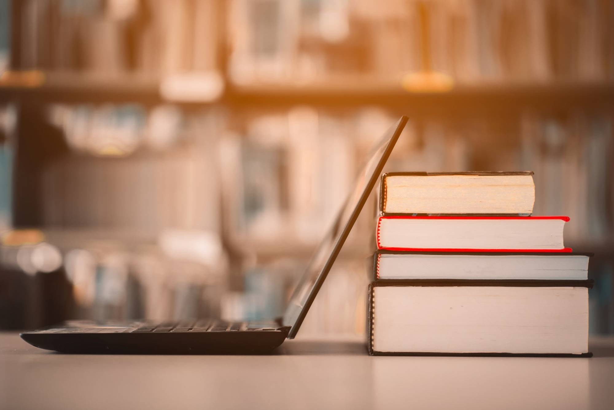 Books and a laptop representing recommended reading on experiential learning